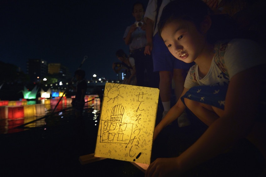 Een meisje plaatst een 'Lantaarn voor Vrede' op de Otan, de rivier die in Hiroshima uitmondt in de Japanse Binnenzee © Paul Jeffrey/WCC Een meisje plaatst een 'Lantaarn voor Vrede' op de Otan, de rivier die in Hiroshima uitmondt in de Japanse Binnenzee © Paul Jeffrey/WCC