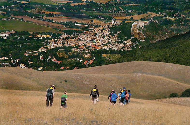 De kinderen dalen de Monte Subasio af, in de verte de stad Assisi. © TAU