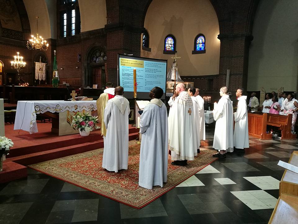 Priesters voor het altaar bij intrede Priesters voor het altaar bij intrede