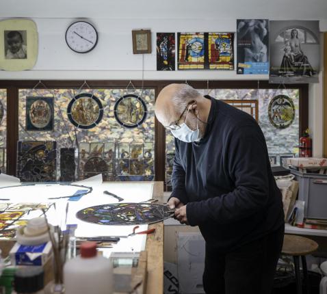 Joost Caen aan het werk in zijn atelier, een schatkamer die heel wat waardevolle  glasramen onderdak biedt.  © Ans Brys