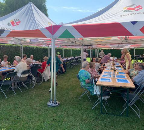 De aanwezigen genieten samen van een gezellige maaltijd in de schaduw van de pastorijtuin © Pastorale zone Leuven aan de Dijle
