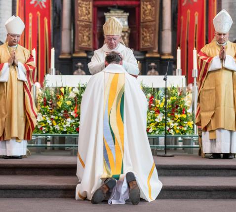 De handoplegging door kardinaal De Kesel. © Belga