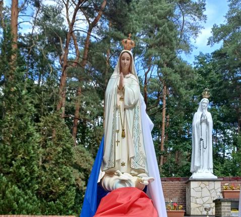 Onze-Lieve-Vrouw kleedden we in de viering aan met kleurrijke mantels die symbool stonden voor trouw, liefde en hoop. In de achtergrond het beeld van Maria van kunstenaar Jan Boedts. Fatima is een geweldige stilteplek. Loop er zo nu en dan eens aan. 