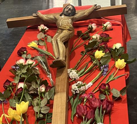 Mensen eren het kruis met een bloem 