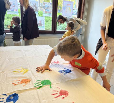  Kinderen zetten hun handdruk op de altaardwaal. 