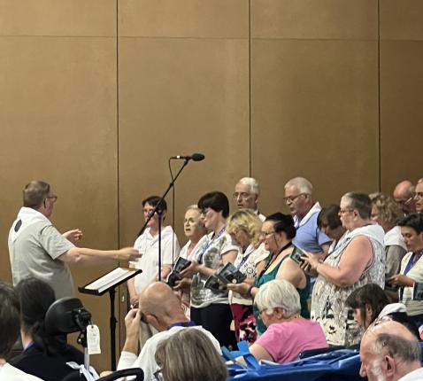 Het koor zingt onder leiding van Chrétien 