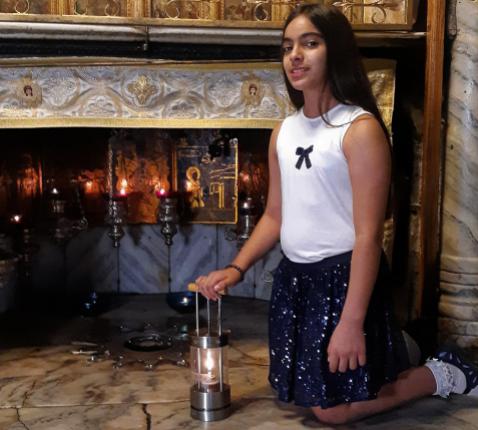 Pillar Jarayseh (12) haalt het vredeslicht op in de geboortegrot in Betlehem © ORF