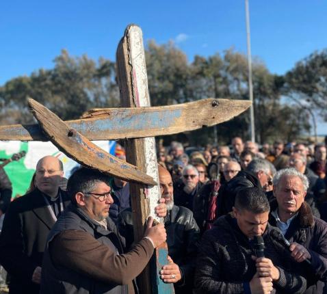 De deelnemers dragen afwisselend het kruis, gemaakt uit het wrakhout van het bootje, waarmee 200 vluchtelingen op 26 februari uit Turkije vertrokken. © Vatican News