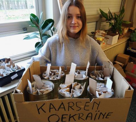 Angelina met enkele blikken om te vullen. Deze kaarsen branden zo’n 20 uur © Pastorale zone Leuven aan de Dijle