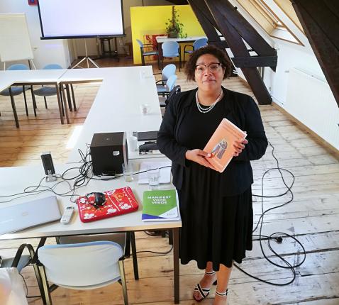 Bénédicte Kusendila, met een boek over Sint-Franciscus in de hand en het Manifest voor Vrede © Pax Christi Vlaanderen
