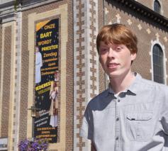 Je kan er niet naast kijken: aan de kerk hangt een groot spandoek met 'Onze Bart wordt priester'. © Tony Dupont