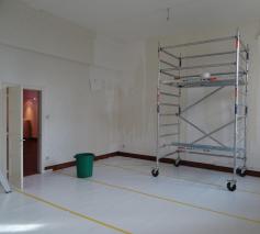 De vloer krijgt een tijdelijke beschermlaag. Oud behangpapier wordt verwijderd. 