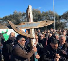 De deelnemers dragen afwisselend het kruis, gemaakt uit het wrakhout van het bootje, waarmee 200 vluchtelingen op 26 februari uit Turkije vertrokken. © Vatican News