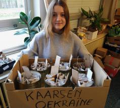 Angelina met enkele blikken om te vullen. Deze kaarsen branden zo’n 20 uur © Pastorale zone Leuven aan de Dijle