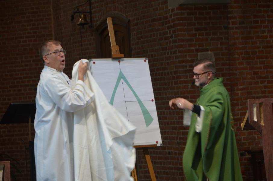 Pastor Gino en diaken Dirk onthullen het nieuwe logo van onze pastorale eenheid Aleidis op zondag 26 juni. 