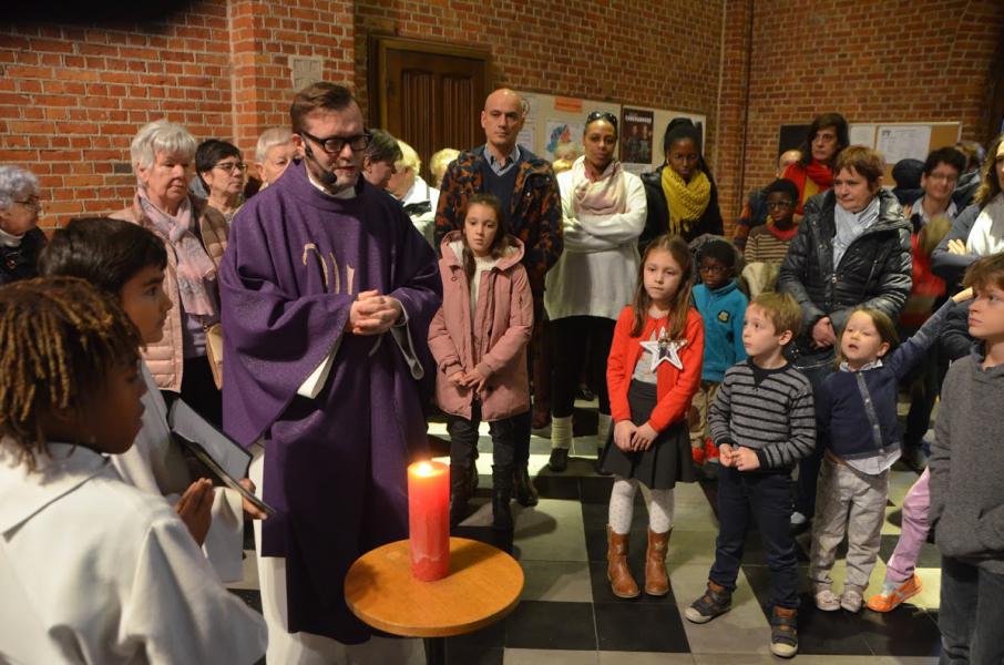 Pastor Gino steekt de eerste kaars van de adventskrans aan. © Luc Faems