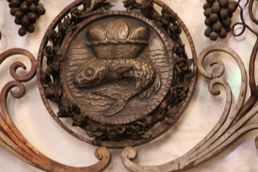 één van de vier taferelen van de voormalige communiebank in de apsis van de kerk - werk van Alberic Plettinck - de vis en de broden © Mia Verbanck
