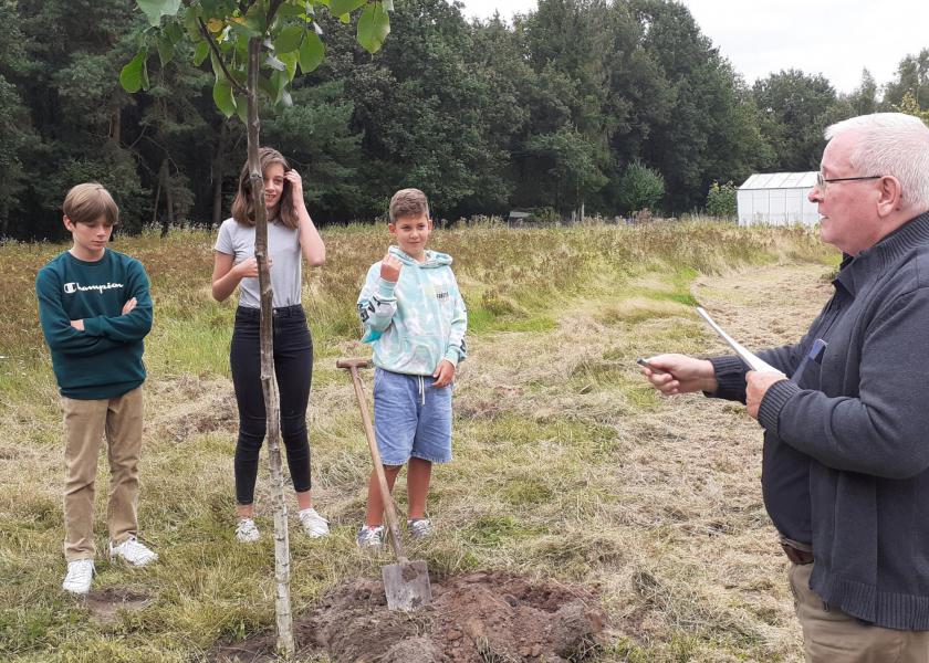 Pater Theo zegent de jonge bomen met wijwater © RB