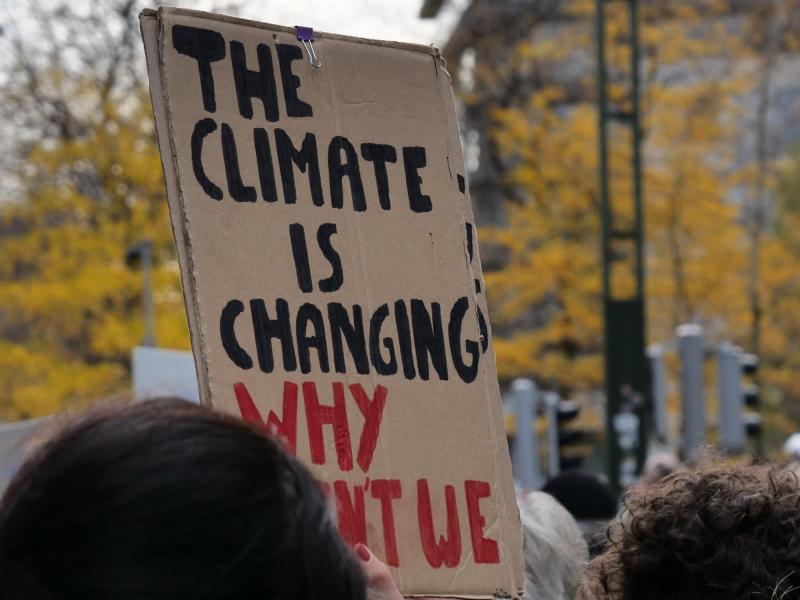 Een van de protestborden: 'The climate is changing, why can't we?' © Michiel Van Mulders