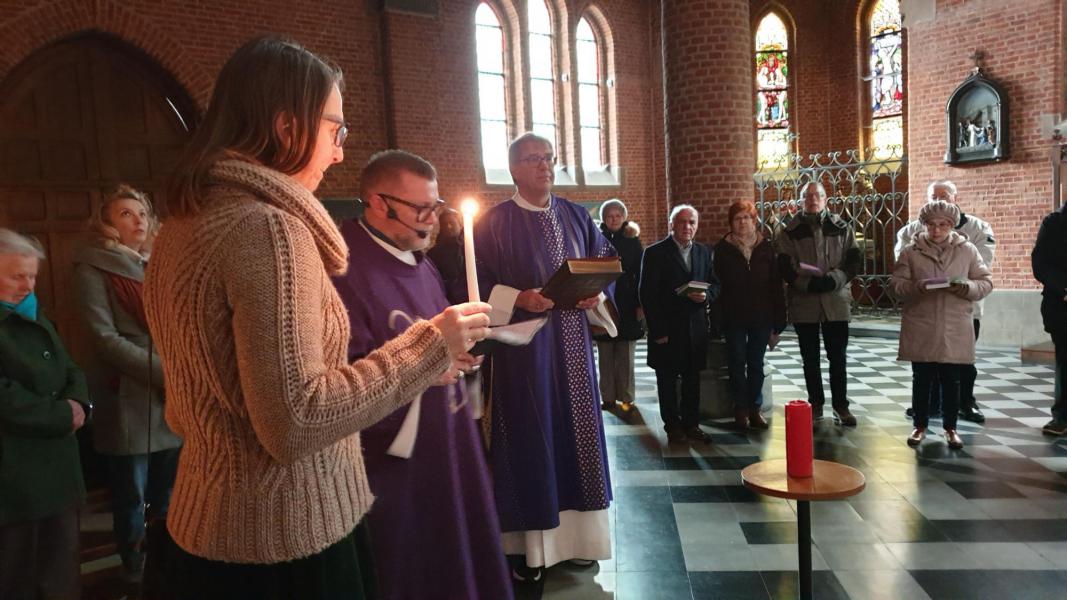 De gemeenschap verzameld zich in het duister achteraan de kerk © Dirk Adams