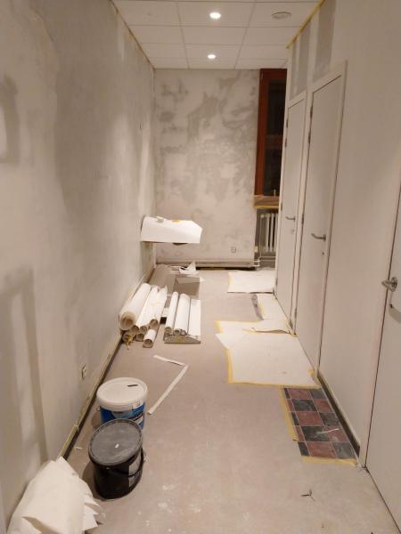 In de gemeenschappelijke toiletten worden de muren klaargemaakt om te schilderen. 