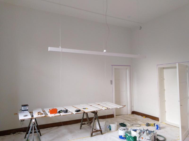 In de gemeenschappelijke living worden de laatste schilderwerken uitgevoerd en de verlichting opgehangen. 