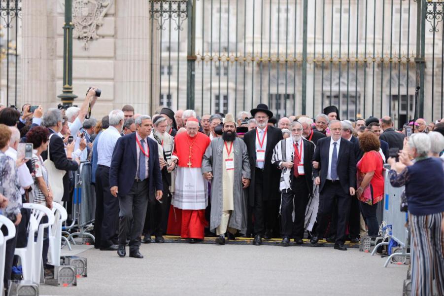 Stoet religieuze leiders stapt op met koninklijk paleis in Madrid op de achtergrond © Sant'Egidio