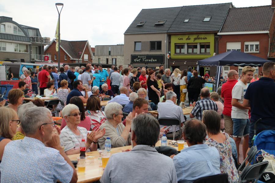 Een dorpsplein vol meevierende mensen © RvH
