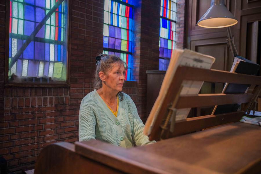 Nicole De Paepe begeleidde de liederen op piano. Voor de viering en bij het einde ervan speelde ze op het grote pijporgel boven. © Wim Duysburgh