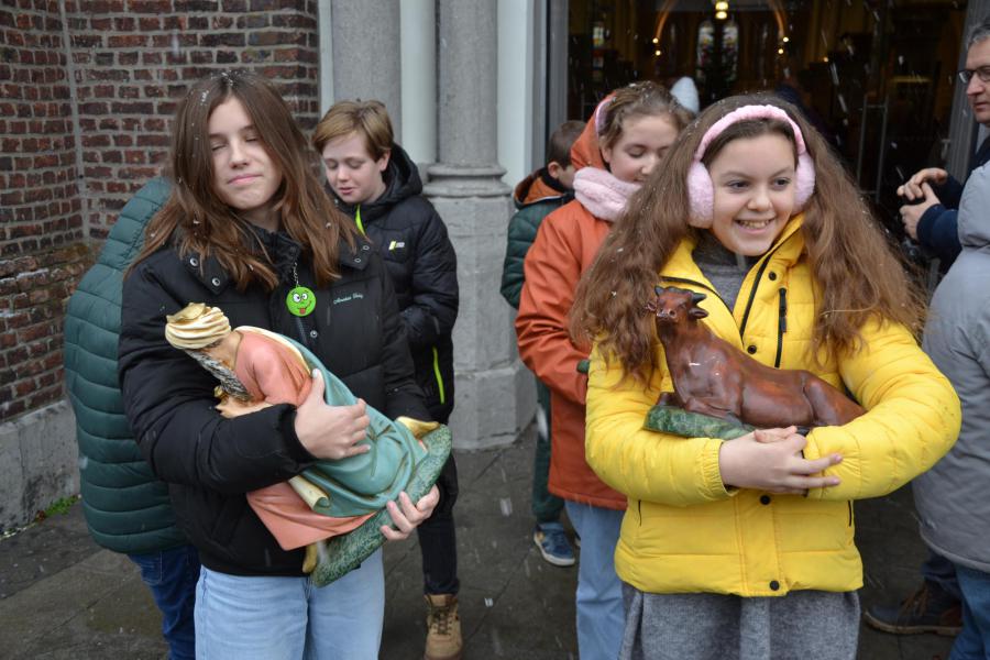 Enkele vormelingen dragen de kerstbeelden tot bij de stal © Hans van Hove