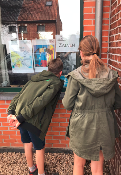 Vormelingen Emile en Aline bestuderen het raam over zalven (met chrisma) 