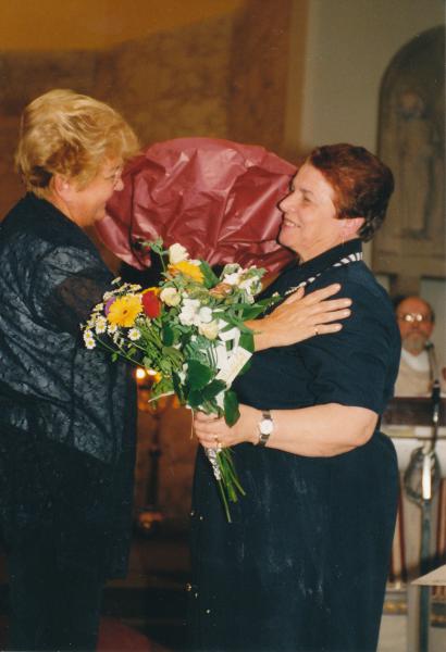 Diocesane decoratie in 2000: Jozefa Vangoidsenhoven overhandigt Rosa een ruiker bloemen namens het parochieteam  © Mia Verbanck