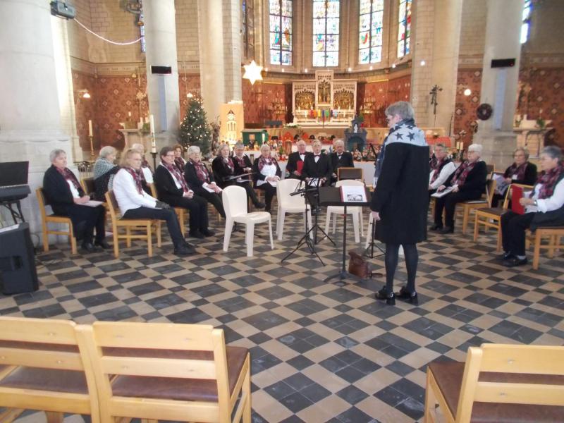 Het koor aan het inzingen met op de achtergrond de kerststal 