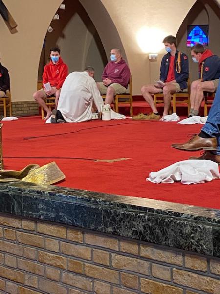 Pastoor Dirk waste de voeten van de jongeren.  © D.D.