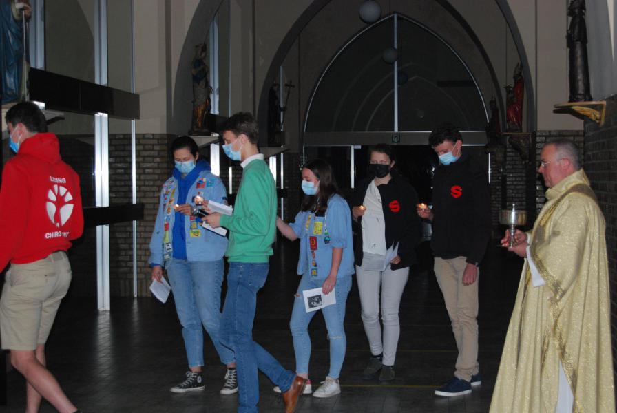 Met lichtjes brengen de jongeren met pastoor Dirk het Heilig Sacrament naar het rustaltaar.  © D.D.