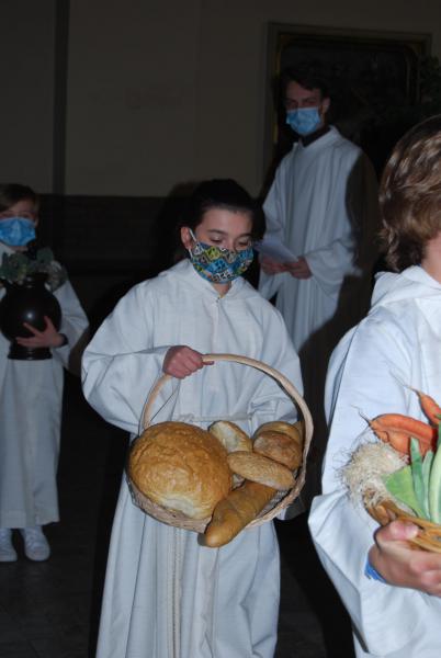 Misdienaar Mats bracht een grote korf met vruchten aan en misdienaar Selena zorgde voor het brood, met veel dank aan bakker Gregory.  © D.D.