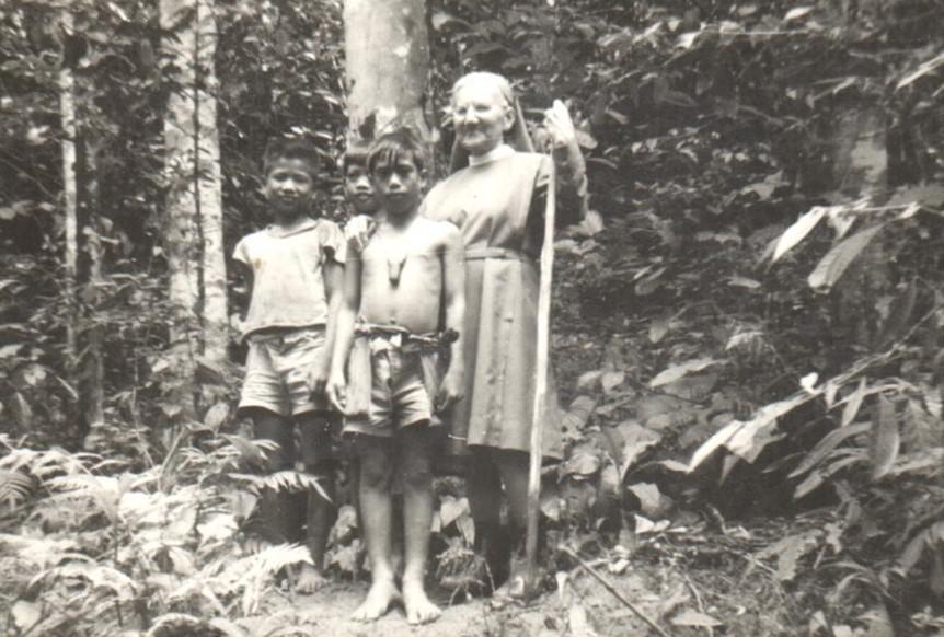Zuster Renata met haar wandelstok in de brousse, samen met inheemse kinderen © Denise Cnockaert