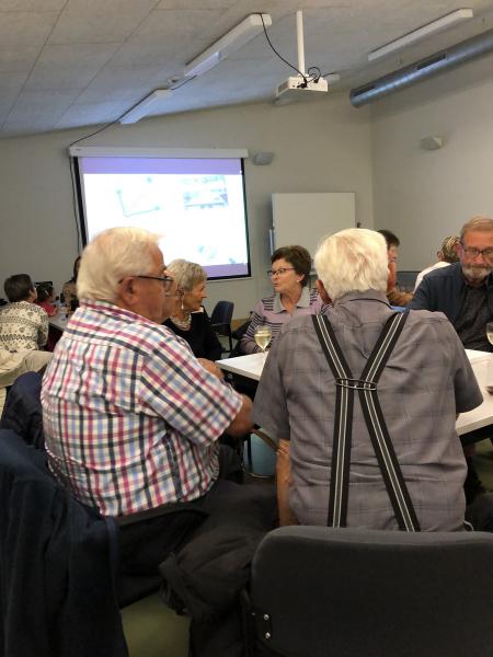 Een groep bezoekers, gezellig met elkaar keuvelend 