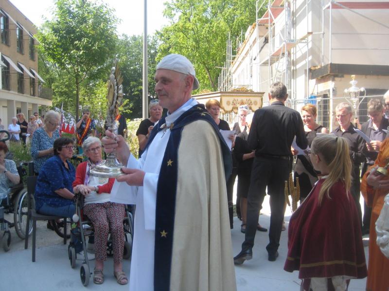 In het Parkhof waren de bewoners en hun begeleiders opgetogen dat de processie bij hen langskwam en dat priester Piet Capoen hen zegende. Merk achteraan ook het koor uit Diegem dat passende liederen bracht.  © L.J. 