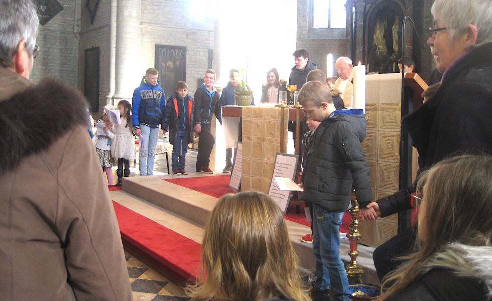 Alle kinderen en jongeren samen rond het altaar bij het Onzevader; allemaal raakten ze wel niet op de foto. © L.J 