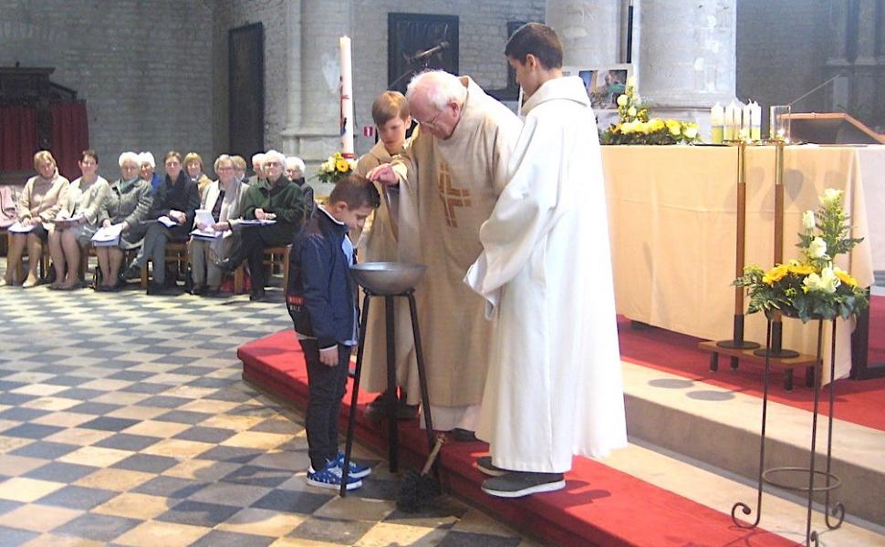 Vijf kinderen werden gedoopt met het pas gezegende water. Zo werden ze opgenomen in de gemeenschap van de Kerk van Jezus. L.J. 