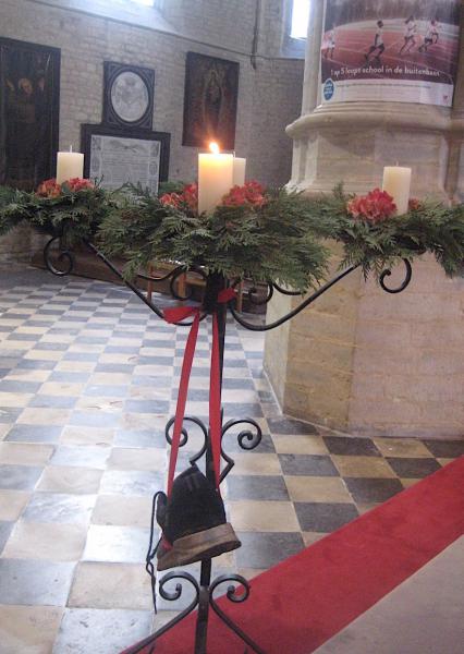 De eerste kaars op de adventskrans brandt. Deze versleten schoen verwijst naar kinderen in armoede die altijd achterop raken. © L.J. 