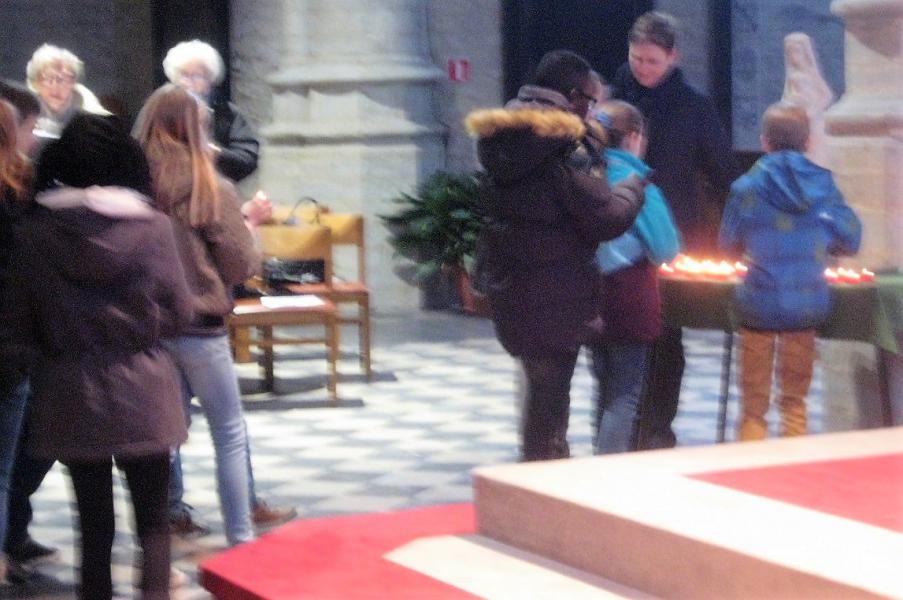 De kinderen openen de viering met het branden van een kaarsje bij Maria.  