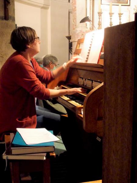 Zoals steeds - een beetje verscholen achter het orgel en een pilaar - organiste Annelynn Ballieu, die al jaren het beste van zichzelf heeft gegeven. © Hugo Hollé