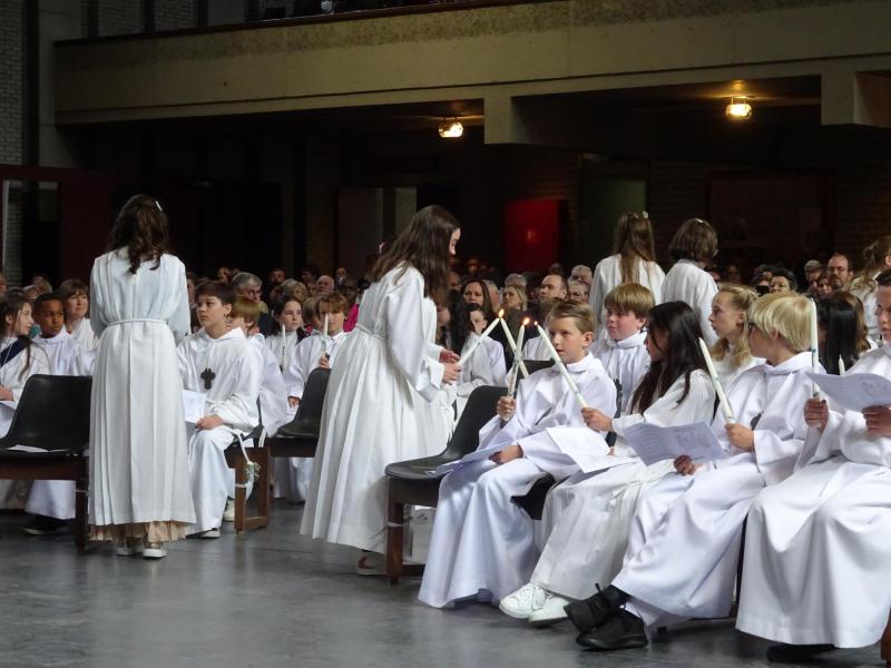 Vormelingen van Pius X en Onze-Lieve-Vrouw Middelares geven van het licht van de paaskaars door tijdens de vormselviering van 7 mei 2022 