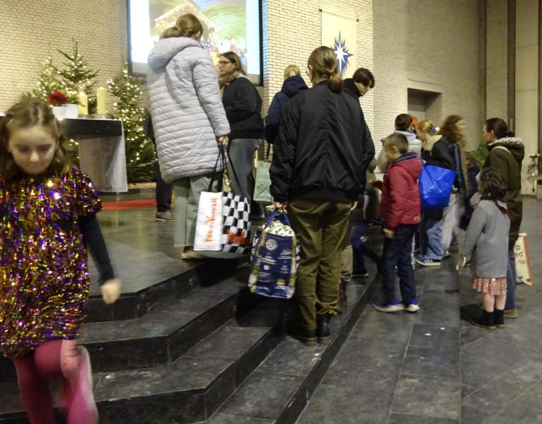 De kinderen leggen hun pakjes bij de kerststal. © Marjo Perry