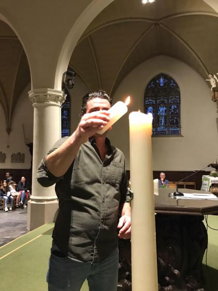 De doopkaars van Lio wordt aangestoken aan de paaskaars 