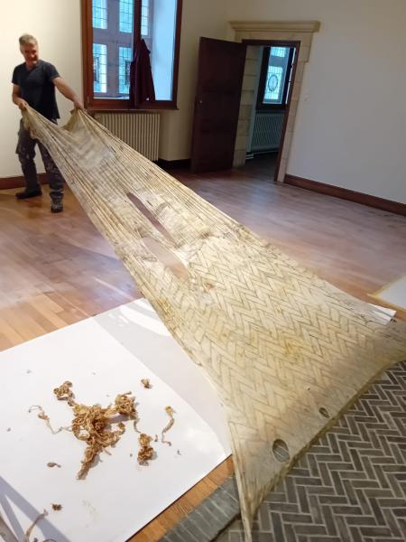 Met een nieuw product reinigt werkman Geert de elementen in steen in de kamers. Eerst brengt hij het product - een soort gel - aan waarna het enkele dagen kan intrekken en hard worden. Vervolgens trekt hij het een vlies waaraan alle vuil kleeft weg. 