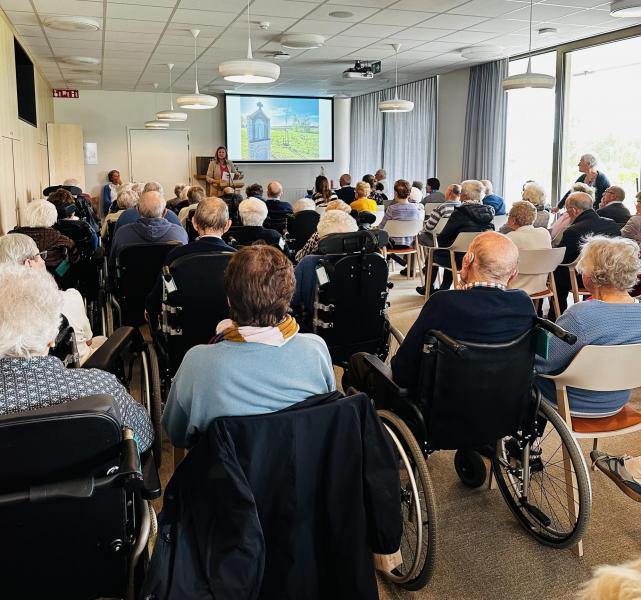 Het weer viel tegen, maar bewoners konden de inzegening binnen volgen op groot scherm. © Mia Vervaeck