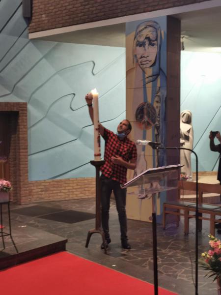 Jesus ontsteekt de doopkaars aan het paaslicht. 